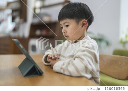 タブレットPCの画面を見る7歳の男の子 110016566