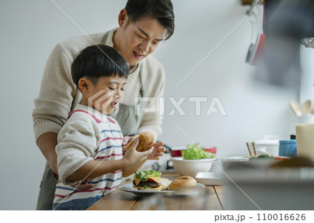 キッチンでハンバーガーを作る30代の父親と小学生の息子 110016626