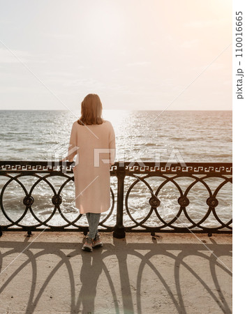 Woman summer travel sea. Happy tourist enjoy taking picture outdoors for memories. Carefree woman traveler posing on beach at sea on sunset, sharing travel adventure journey. Holiday vacation concept. Woman summer travel sea. Happy tourist enjoy taking picture outdoors for memories. Carefree woman traveler posing on beach at sea on sunset, sharing travel adventure journey. Holiday vacation concept. 110016665