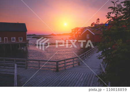 The embankment on the rocky seashore at sunset. Fishing village near the sea. Beautiful nature of Norway. Lofoten islands The embankment on the rocky seashore at sunset. Fishing village near the sea. Beautiful nature of Norway. Lofoten islands 110018859