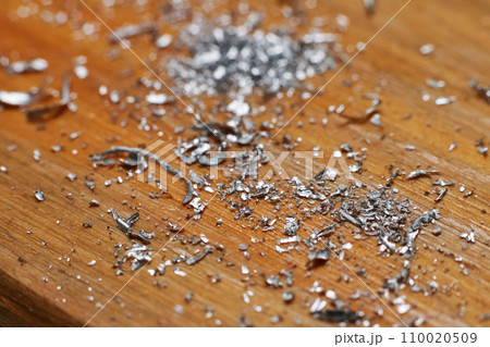 Small metal chips on a wooden background Small metal chips on a wooden background 110020509