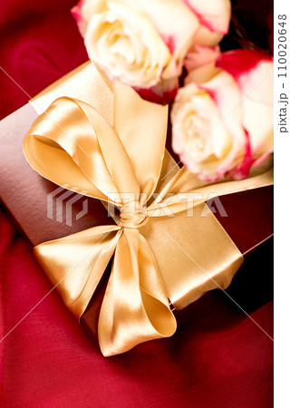 flowers and gift. Vintage pink flowers and gift box with ribbon on a light table for birthday, women's day or mother's day flowers and gift. Vintage pink flowers and gift box with ribbon on a light table for birthday, women's day or mother's day 110020648