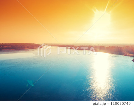 Magical sunset over the frozen lake. Serene lake in the evening. Nature landscape 110020749