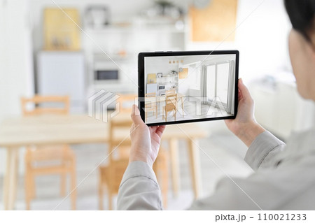 ARアプリを使って家具の配置をシミュレーションする女性 ARアプリを使って家具の配置をシミュレーションする女性 110021233