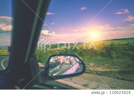 Driving a car on the road on a sunny day. View from the car on a mountain landscape 110023029