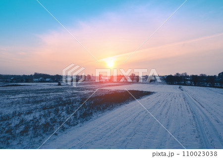 Rural landscape in winter. Countryside. A field covered with snow at sunset 110023038