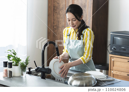 食器を洗うエプロン姿の女性 食器を洗うエプロン姿の女性 110024806