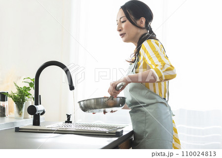 食器を洗うエプロン姿の女性 食器を洗うエプロン姿の女性 110024813