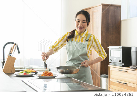 料理に盛り付けする女性 110024863