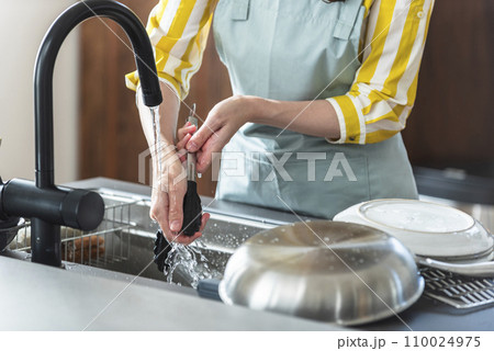 食器を洗うエプロン姿の女性 110024975