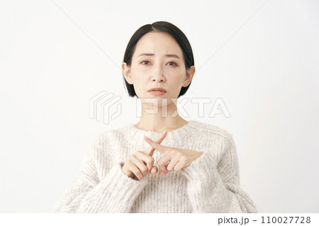 指でばつ印のジェスチャーをする中年女性 白背景 指でばつ印のジェスチャーをする中年女性 白背景 110027728