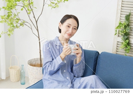 自宅でパジャマを着てマグカップを持って寛ぐ中年女性 自宅でパジャマを着てマグカップを持って寛ぐ中年女性 110027769
