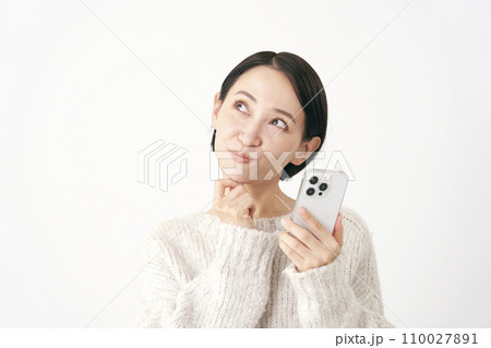 スマホを持って想像する中年女性 白背景 スマホを持って想像する中年女性 白背景 110027891