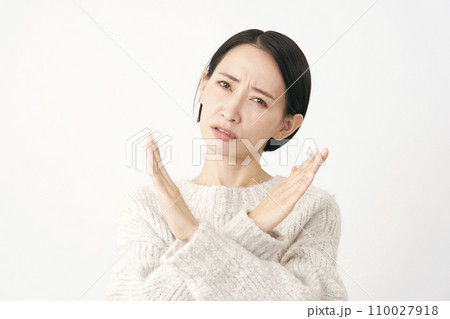 腕でばつ印のジェスチャーをする中年女性 白背景 腕でばつ印のジェスチャーをする中年女性 白背景 110027918