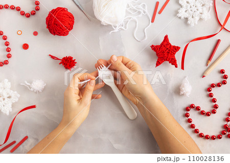 Making pom-poms from red and white threads. Ideas of Christmas decoration diy with kids 110028136