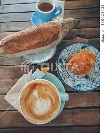 Sourdough bread and chocolate croissant paired with cappuccino and espresso, rustic autumn aesthetic Sourdough bread and chocolate croissant paired with cappuccino and espresso, rustic autumn aesthetic 110028533