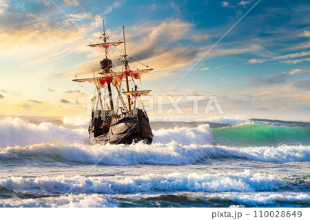 Grand view of an old sailing ship from the times of pirates on the high seas with big waves Grand view of an old sailing ship from the times of pirates on the high seas with big waves 110028649