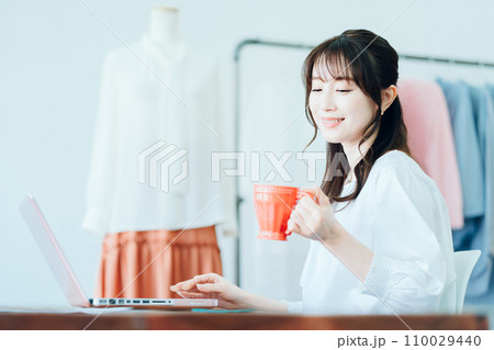 リビングでテレワーク中に休憩をする若い女性 110029440