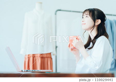 リビングでテレワーク中に休憩をする若い女性 リビングでテレワーク中に休憩をする若い女性 110029441