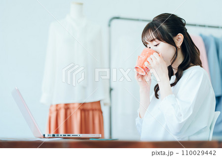 リビングでテレワーク中に休憩をする若い女性 110029442