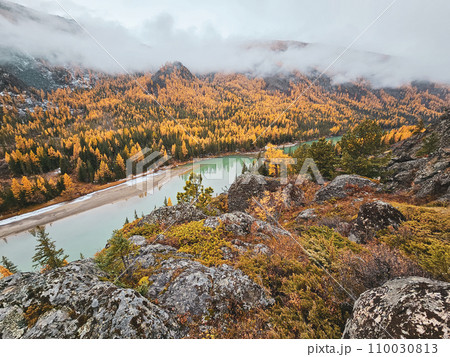 Granite cliff above the river. Stunning winding turquoise river in an autumn mountain valley. Beautiful autumn landscape in the mountains, river and colorful forest. 110030813