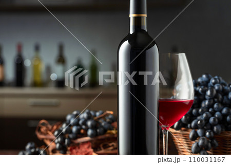 Bottle and glass of red wine with blue grapes. Bottle and glass of red wine with blue grapes. 110031167