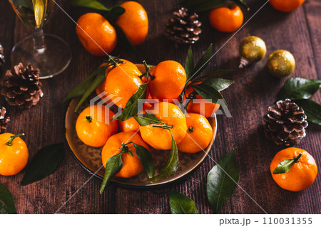 Fresh tangerines with leaves on a plate on the Christmas table 110031355