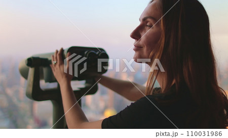 Woman enjoy Bangkok cityscape on Baiyoke Tower Sky viewpoint. Girl looking in binoculars telescope on observation deck for tourist. City skyline panorama at sunset. Travel, tourism, visit Thailand Woman enjoy Bangkok cityscape on Baiyoke Tower Sky viewpoint. Girl looking in binoculars telescope on observation deck for tourist. City skyline panorama at sunset. Travel, tourism, visit Thailand 110031986