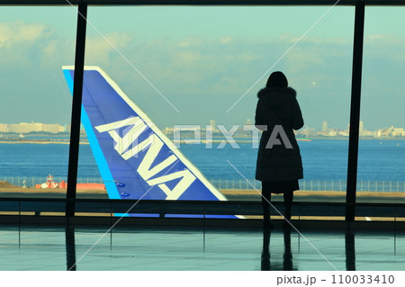 羽田空港第2ターミナル国際線ロビー　飛行機を眺める女性　男女 110033410