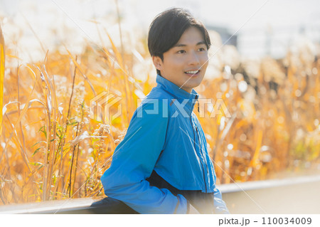 ススキの野原を歩く男性　 110034009