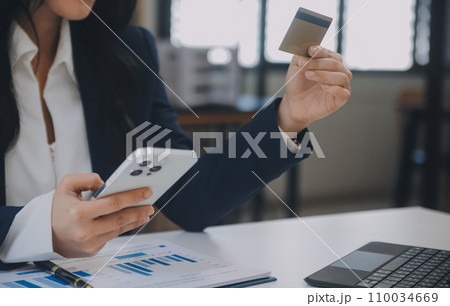 Women holding credit card and using smartphones at home.Online shopping, internet banking, store online, payment, spending money, e-commerce payment at the store, credit card, concept 110034669