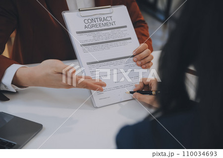 Lawyer, legal advisor, businessman brainstorming information on agreement details Business contracts in legal processing books for accuracy in contract documents. joint financial investment. 110034693