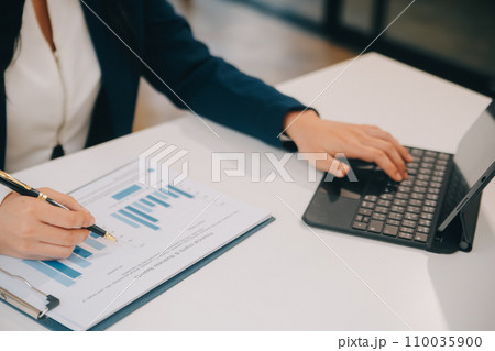 Financial analysts analyze business financial reports on a digital tablet planning investment project during a discussion at a meeting of corporate showing the results of their successful teamwork. 110035900