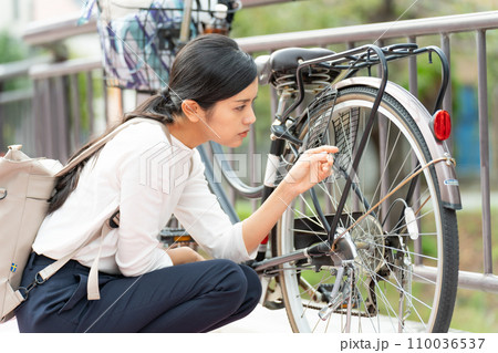 自転車(ママチャリ)の故障に困る若い女性 自転車(ママチャリ)の故障に困る若い女性 110036537