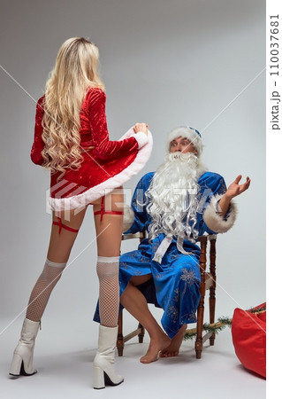 Erotic surprise for a Santa Claus in white studio 110037681