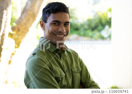 Portrait of happy biracial man standing next to window at home 110039741