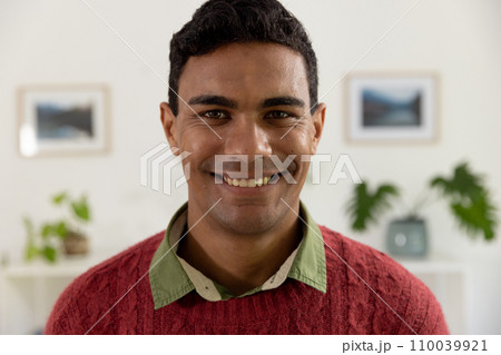 Portrait of happy biracial man with black hair smiling at home 110039921
