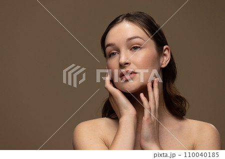 Caucasian woman with brown hair wearing natural makeup on beige background, copy space Caucasian woman with brown hair wearing natural makeup on beige background, copy space 110040185