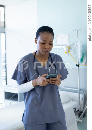 African american female doctor using smartphone in hospital room 110040367