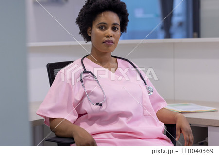 Portrait of african american female doctor sitting in hospital reception 110040369