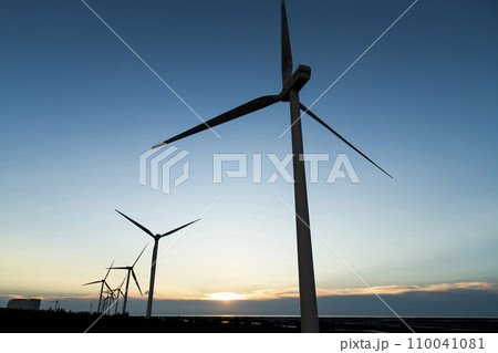 Sunset view of wind power systems with blue sky background on the west coast of Taiwan. Sunset view of wind power systems with blue sky background on the west coast of Taiwan. 110041081