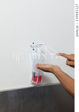 Midsection of biracial female doctor wearing scrubs washing hands in operating theatre, copy space 110041127