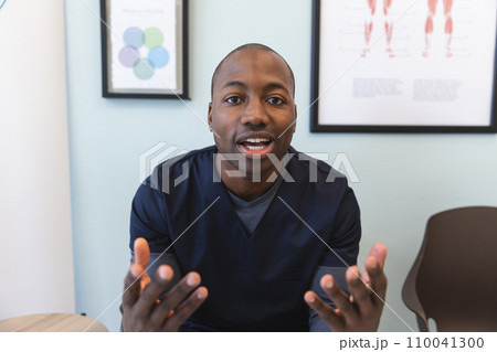 African american male doctor having video call in waiting room in hospital 110041300