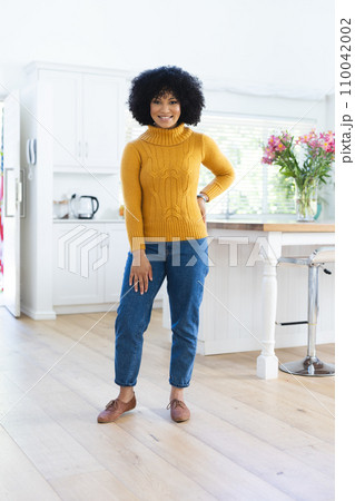 Happy african american woman standing with hand on back at home, copy space Happy african american woman standing with hand on back at home, copy space 110042002