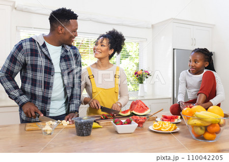 Happy african american family preparing fresh snack from fruits in kitchen at home, copy space 110042205