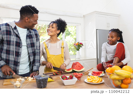 Happy african american family preparing fresh snack from fruits in kitchen at home, copy space Happy african american family preparing fresh snack from fruits in kitchen at home, copy space 110042212