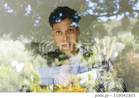 Happy diverse couple embracing and standing by window at home, copy space 110042805