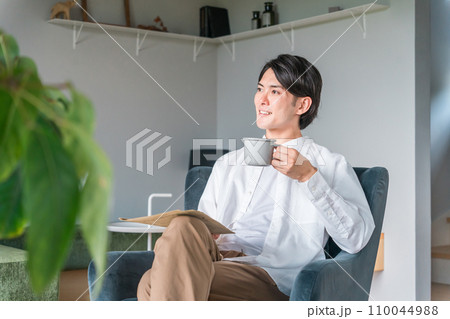 朝コーヒーを飲みながら英字新聞を読む日本人男性（日曜日・リラックス） 110044988