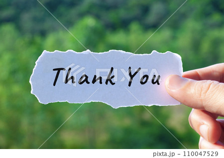 Thank you text on torn white paper with nature background. Thank you text on torn white paper with nature background. 110047529