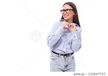 young pretty european brunette business woman with light makeup in a light blue blouse wears glasses 110047737